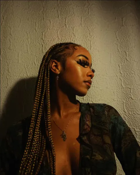 Goddess locs worn long, in warm light